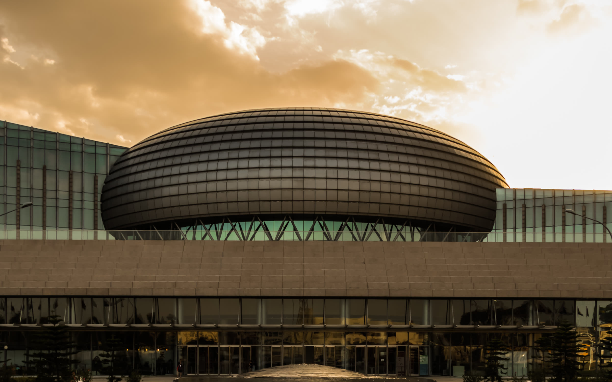 The domed African Union Conference Centre in Addis Ababa under an amber sky